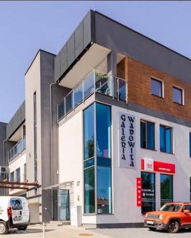a building with an orange car parked in front of it at City Centre Balcony Apartments in Wadowice
