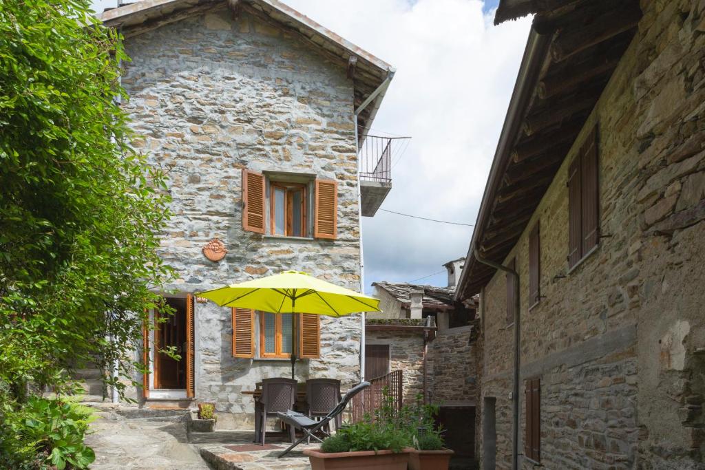 a yellow umbrella in front of a building at Baita LA CANAL in Monastero di Lanzo