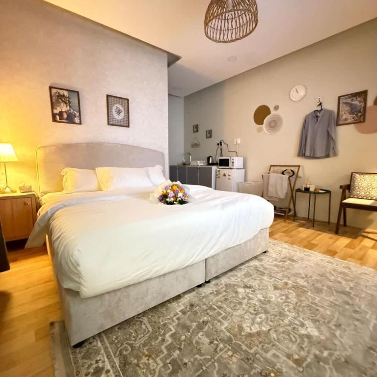 a bedroom with a large white bed with flowers on it at The Italian Studio3 in Dammam