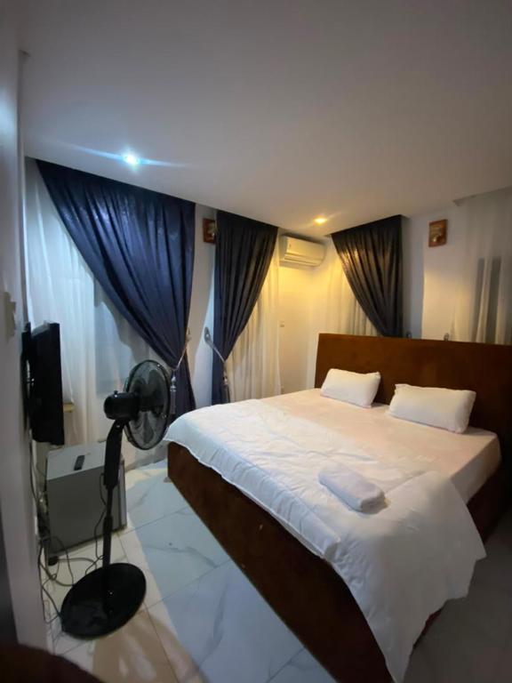 a bedroom with a bed with a fan and curtains at whitestone palace hotel in Eggan