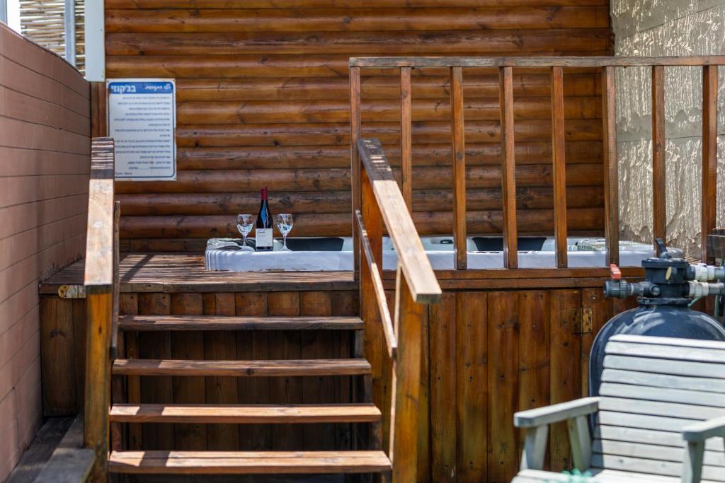 a wooden bar with a table with a bottle of wine at אחוזת שרון in Elifelet