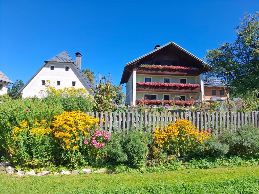 a white house with a white picket fence and flowers at Bauernhof Ablass in Göstling an der Ybbs