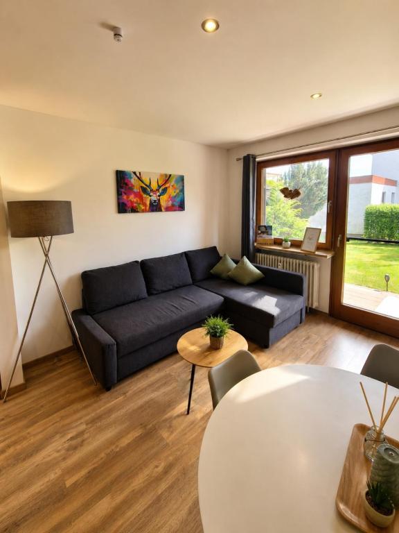 a living room with a black couch and a table at Sarah's Ferienwohnung in Füssen