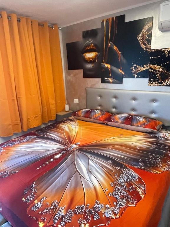 a bedroom with a bed with an orange comforter at B&B Island View in Parzanica