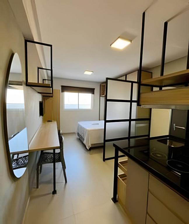 a bedroom with a bed and a desk in a room at Studio Moderno Westfit - Barreto in Mossoró