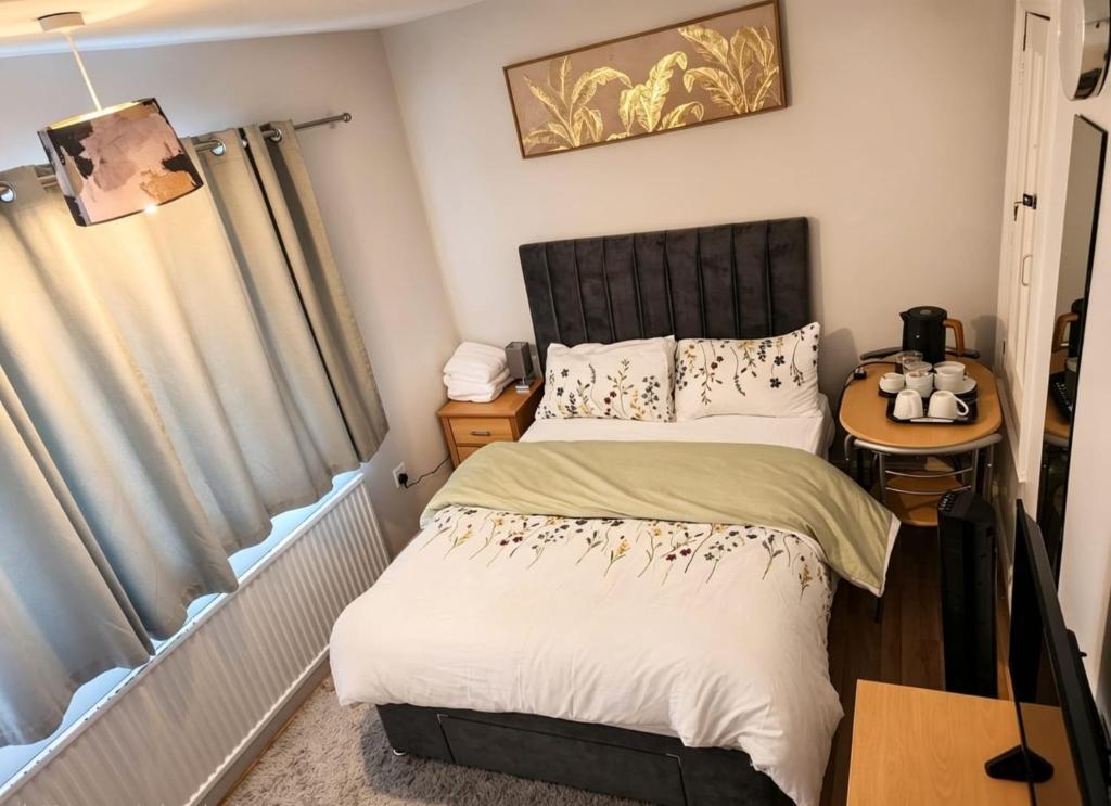 a small bedroom with a bed and a table at Elegant Double Room in Nottingham