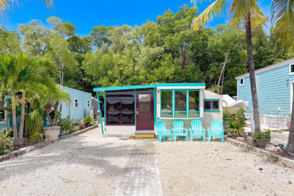 a house on the beach with chairs and palm trees at Key Largo Tiny House, Marina, Beach, and Pool Access in Key Largo