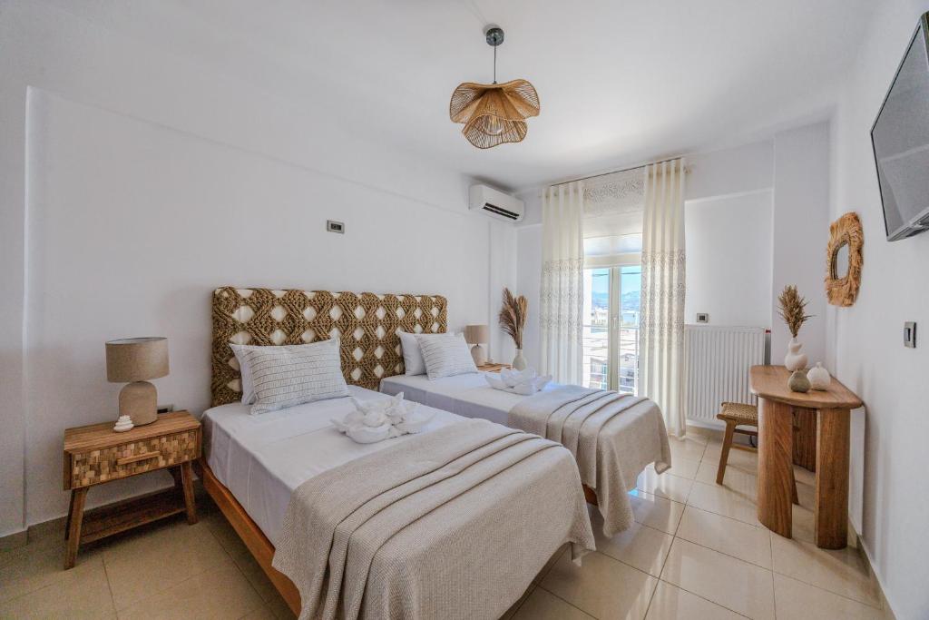 a bedroom with two beds and a window at Casa Di Flora in Agios Prokopios