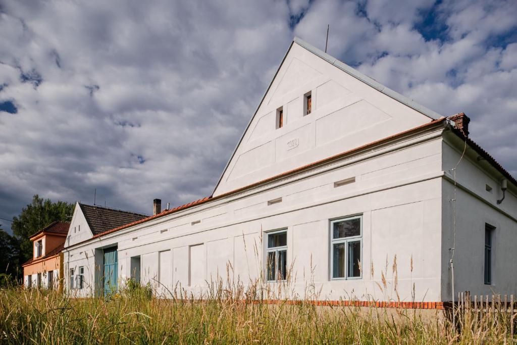 an old white building with a triangular roof at Statek u Benešů in Ponědraž