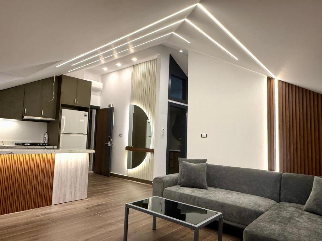 ein Wohnzimmer mit Sofa und Tisch und eine Küche in der Unterkunft Elite Residence - Koura , Near Tripoli in An Nakhlah