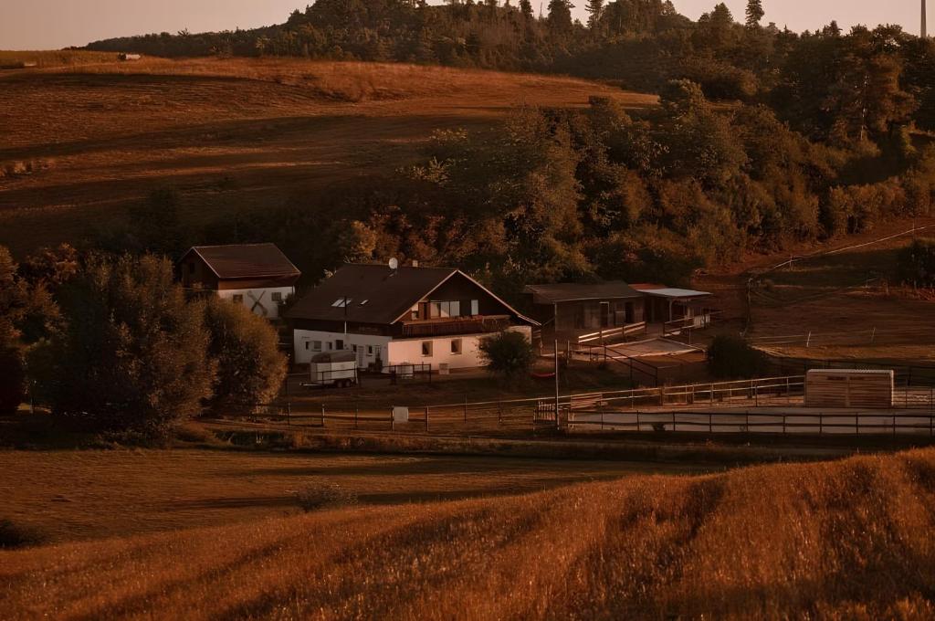 a house on the side of a hill next to a field at Belroki Ranch in Waldeck