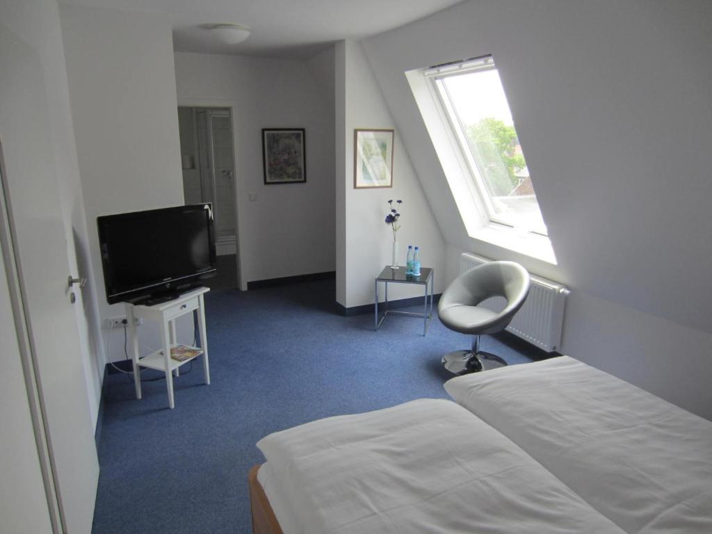 a hotel room with a bed and a television at Hotel Haus Thoeren in Kerken