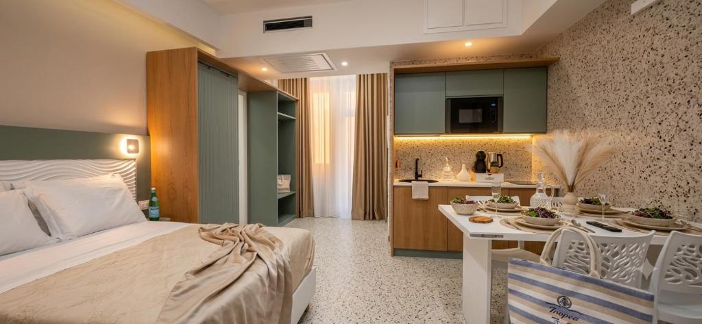 a bedroom with a bed and a kitchen with a table at Salyn Apartments - The Heart of Tropea - Your Perfect Stay in Tropea