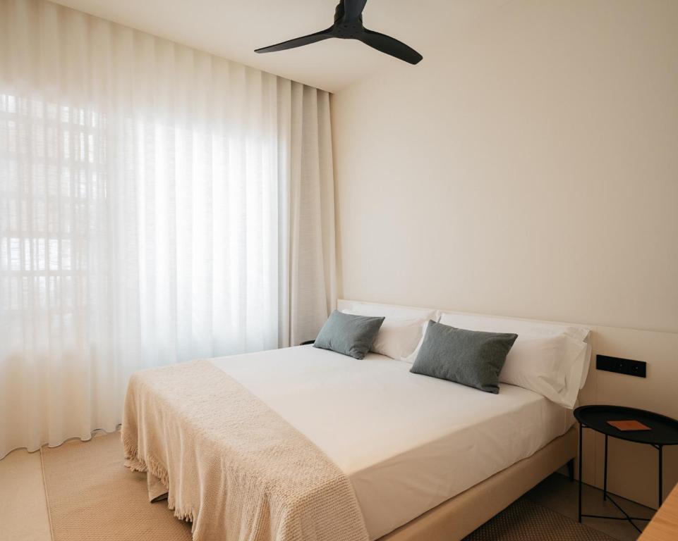 a bedroom with a bed with a ceiling fan at Hostal Serea in Denia