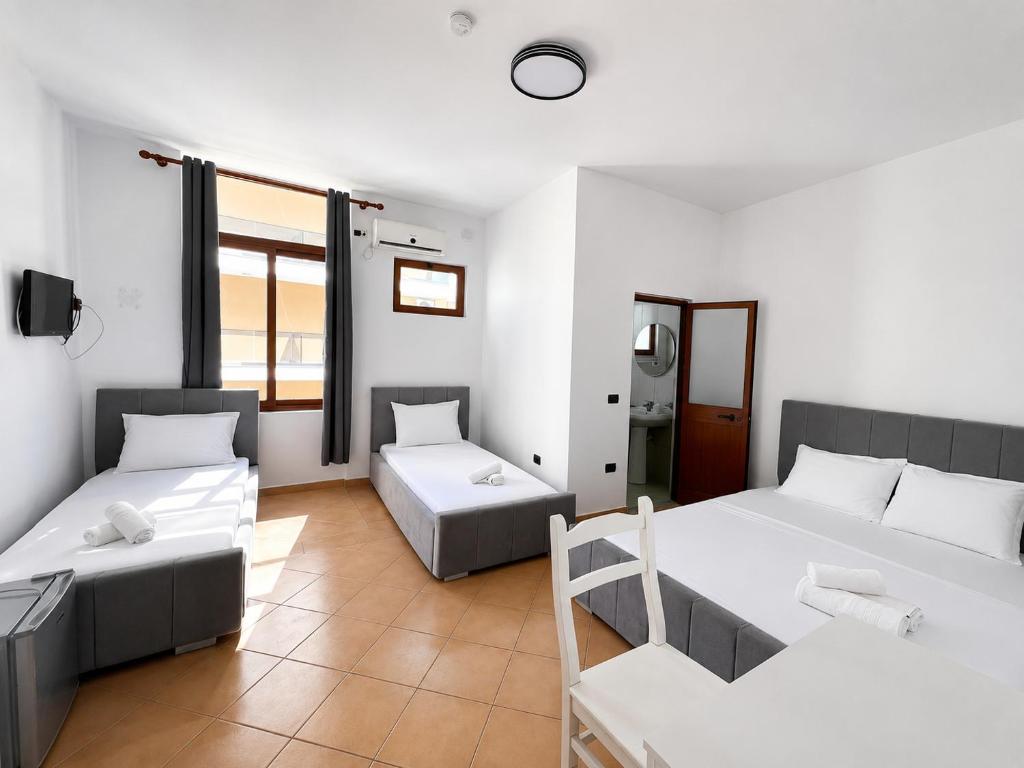 a room with two beds and a couch at Hotel Gjakova-Shëngjin in Shëngjin