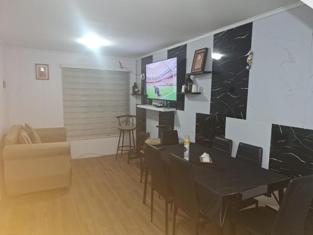 a living room with a television and a table and chairs at Casa agustina 2 in Valdivia