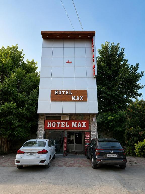 two cars parked in front of a hotel building at HOTEL MAX - In Budget & Comfortable Rooms - For Corporates, Couples, Families Near HMV, DAV, Grain Market, Workshop Chowk in Jalandhar