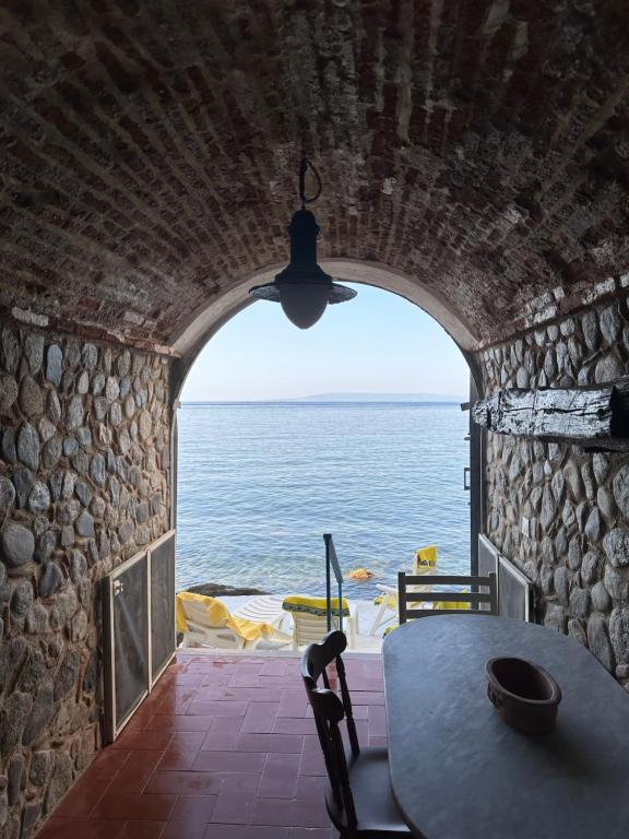 a room with a table and a view of the ocean at Marea Chianalea in Scilla