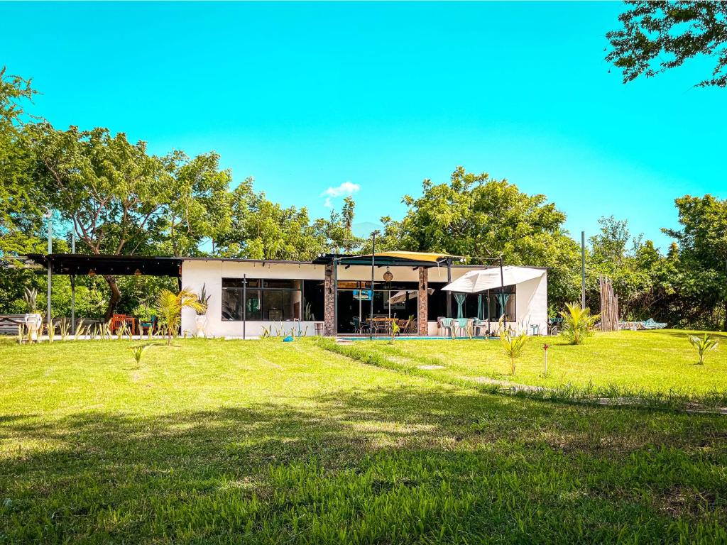 a house with a large yard in front of it at Suite Quelepa San Miguel in Quelepa