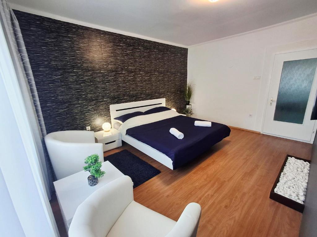 a bedroom with a king sized bed and a couch at MOONLIGHT Prémium APARTMANHÁZ in Sárospatak