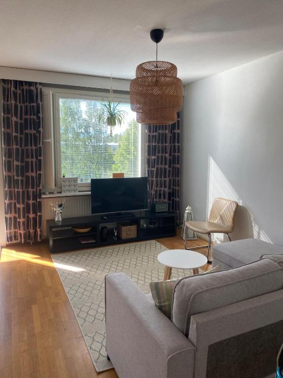 a living room with a couch and a tv at Kasakankuja Kajaani in Kajaani