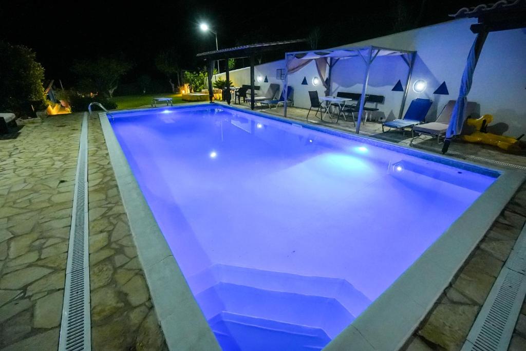 a swimming pool at night with blue lighting at Efi Pool & View Alepochori i in Kato Alepochori