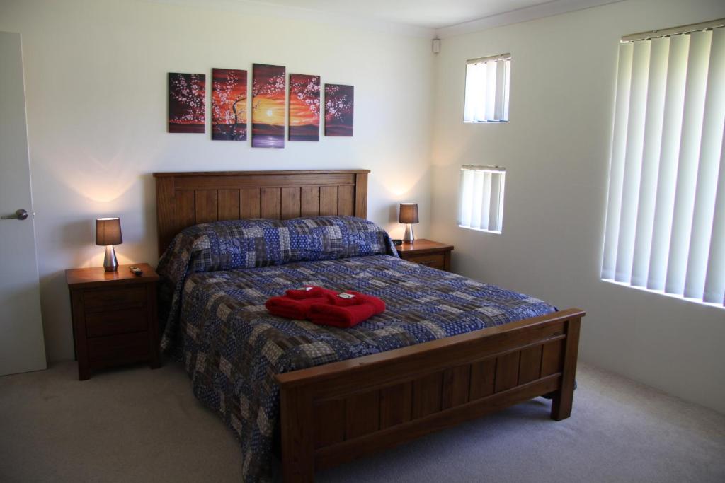 a bedroom with a bed with a pair of red shoes on it at Byford House on the Scarp in Armadale