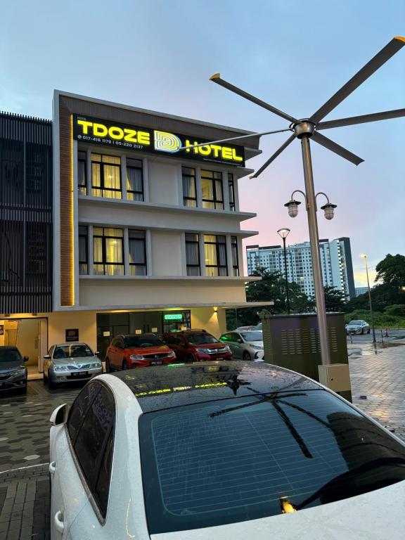 a white car parked in front of a hotel at Tdoze Hotel At Piccadilly Ipoh in Ipoh