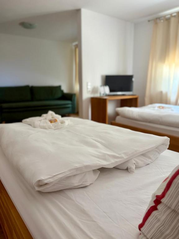 a hotel room with two beds with white sheets at Franz - Josef in Emmingen-Liptingen