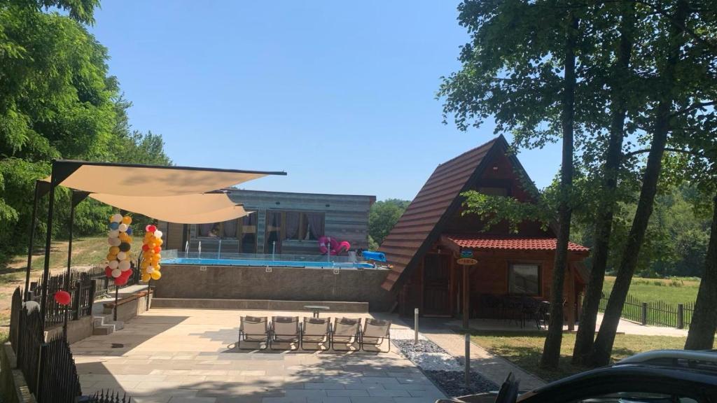 a house with a pool and a patio with chairs at Vila Paradiso in Slatina Varoš