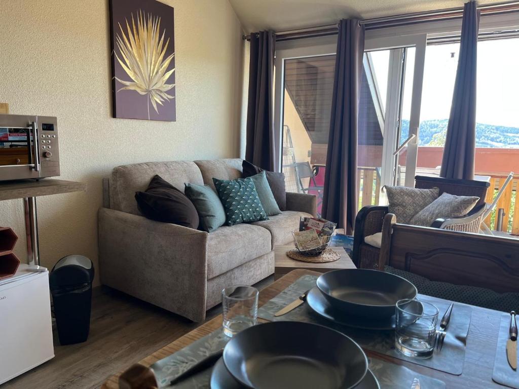 a living room with a couch and a table at Duplex - Proche de Gérardmer in Le Tholy