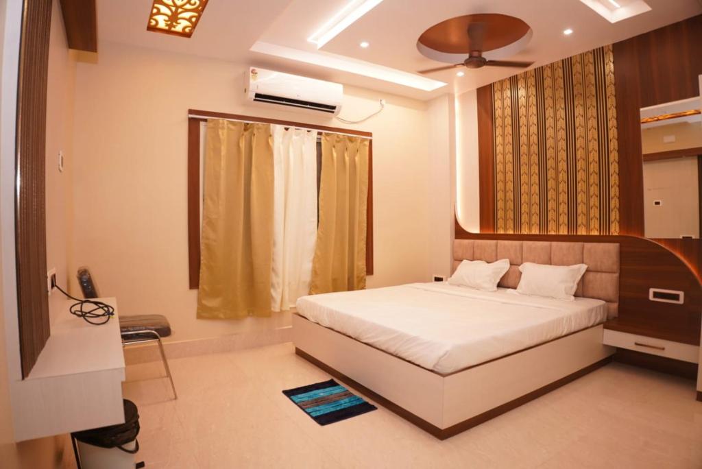 a bedroom with a white bed and a window at Hotel ganga sarovar Inn in Deoghar