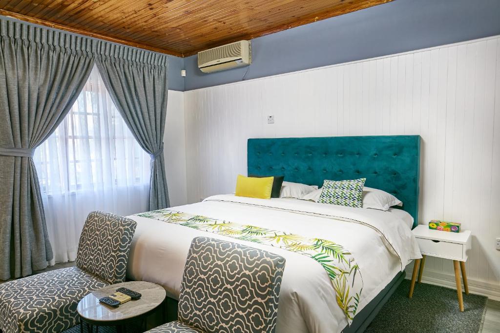 a bedroom with a large bed and a chair at 4bnb in Gaborone