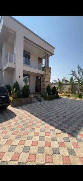 a large house with a stone driveway in front of it at Rj Executive Apartments in Dodoma