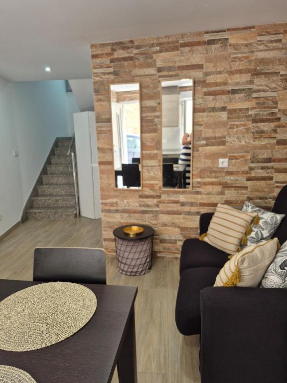 a living room with two couches and a brick wall at Casa Beleví - Laxe, sea and rest in Laxe