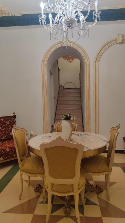 a dining room with a table and chairs and a chandelier at Casa Di Bella Taormina in Roccalumera