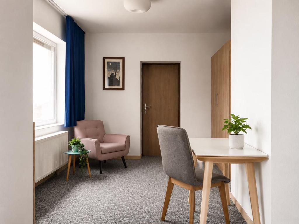 a waiting room with a table and a chair at Penzión Aurora Patince in Patince