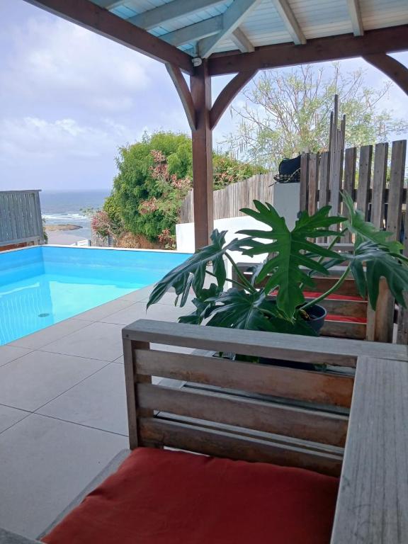 a bench under a gazebo next to a pool at Villa Hill-Sea in Saint Martin