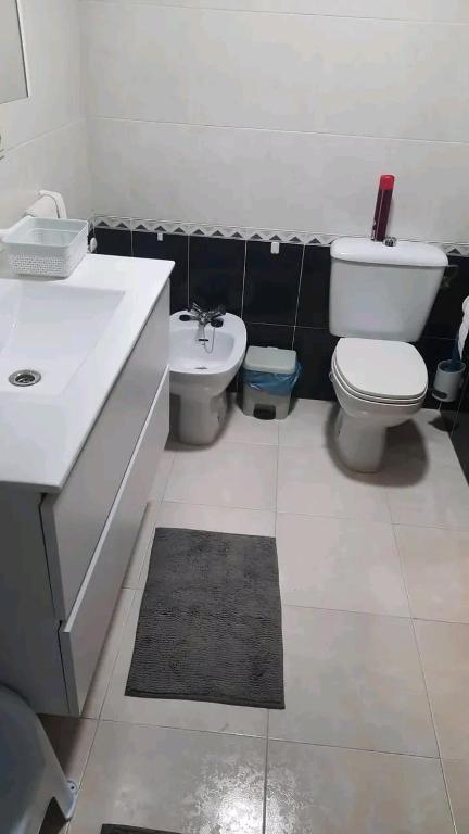 a bathroom with a white toilet and a sink at Arena Maipú in Maipú