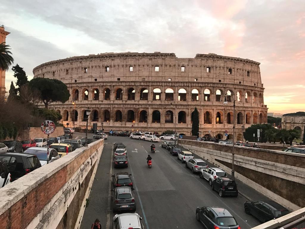 ローマにあるApartment Polveriera Colosseumの車の停車するコロッセオの景色