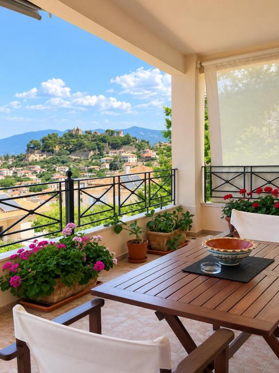a wooden table and chairs on a balcony with flowers at TheA Upper Blue in Kyparissia