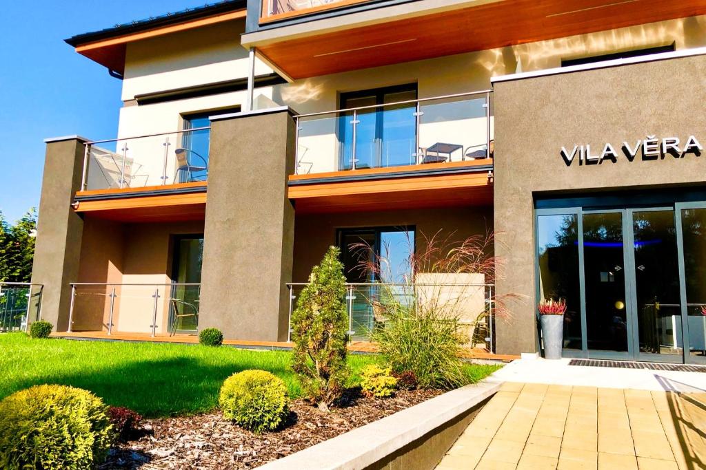 a building with a walkway in front of it at Apartmány Superior Vila Věra in Rožnov pod Radhoštěm