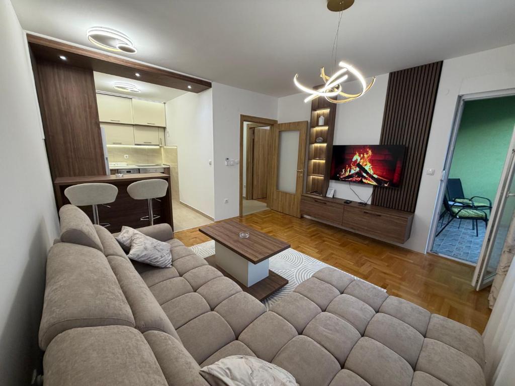 a living room with a couch and a tv at Stan na dan Hilandarska 9 in Lukavica