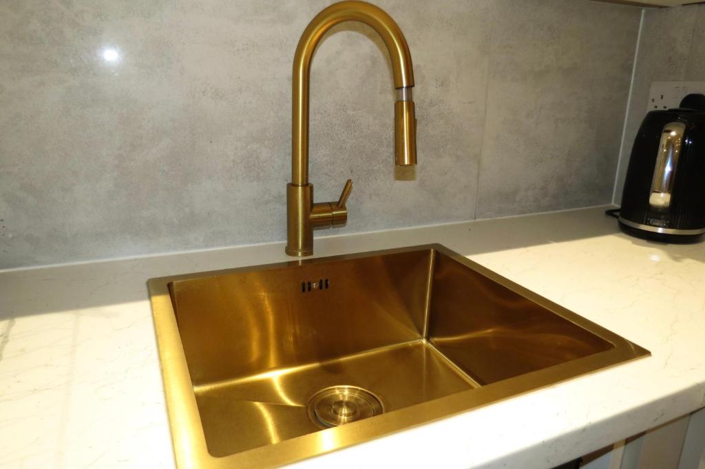 a sink in a kitchen with a gold faucet at Luxury Flats - Hendon in Colindale