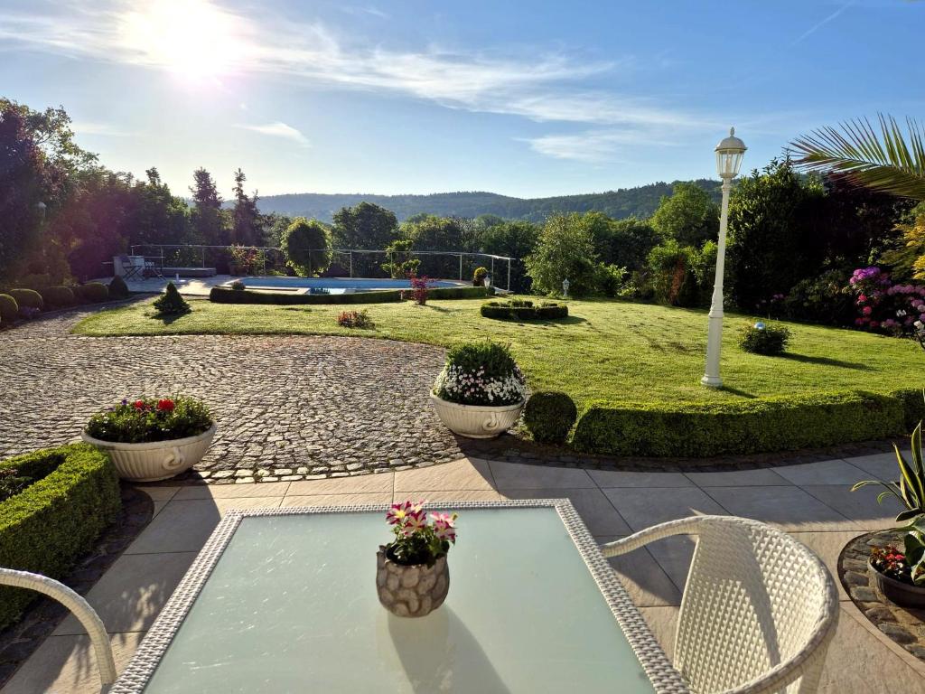 a patio with a table and chairs in a garden at Ihre Auszeit am Golfplatz in Meisdorf