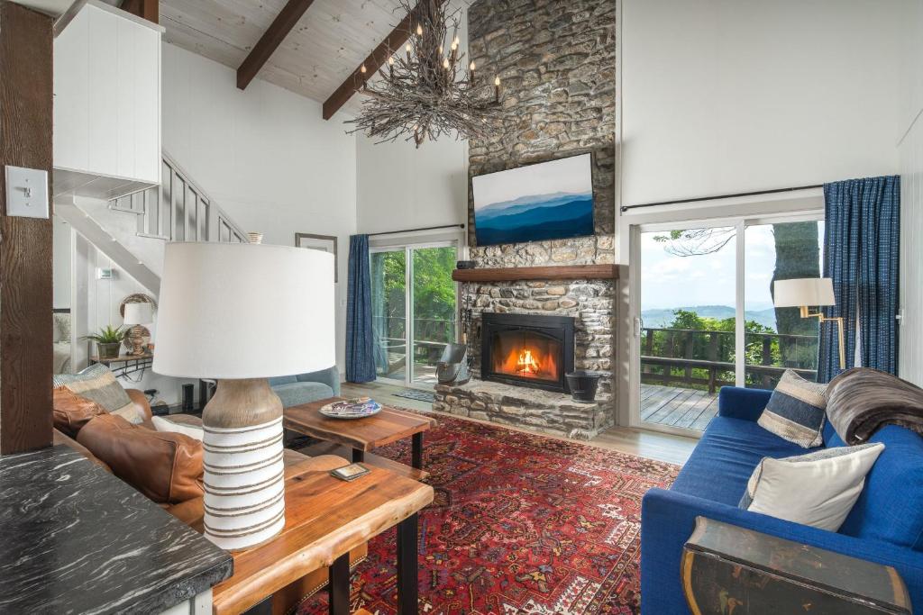 a living room with a blue couch and a fireplace at Blue View Chalet in Blowing Rock