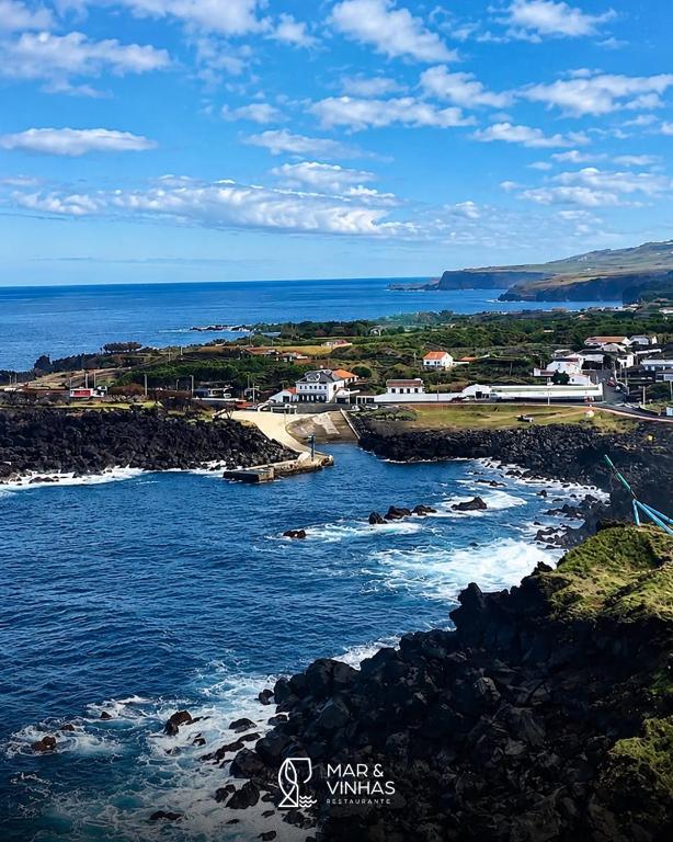 a view of the ocean with a town and buildings at Entre Mar e Vinhas RRAL Nº5668 in Biscoitos