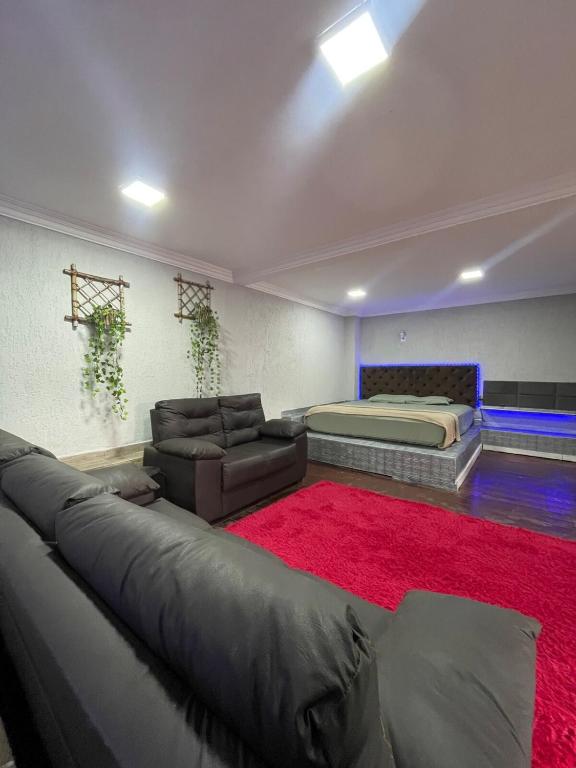 a bedroom with a bed and a couch and a red rug at Mobi Dicky in Nova Friburgo