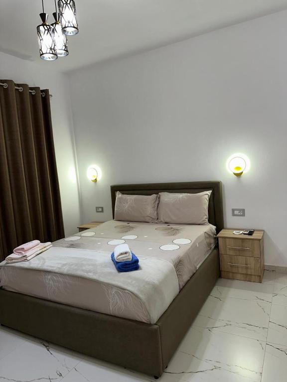 a bedroom with a large bed with two night stands at Bujtina4A Rrenc in Renc