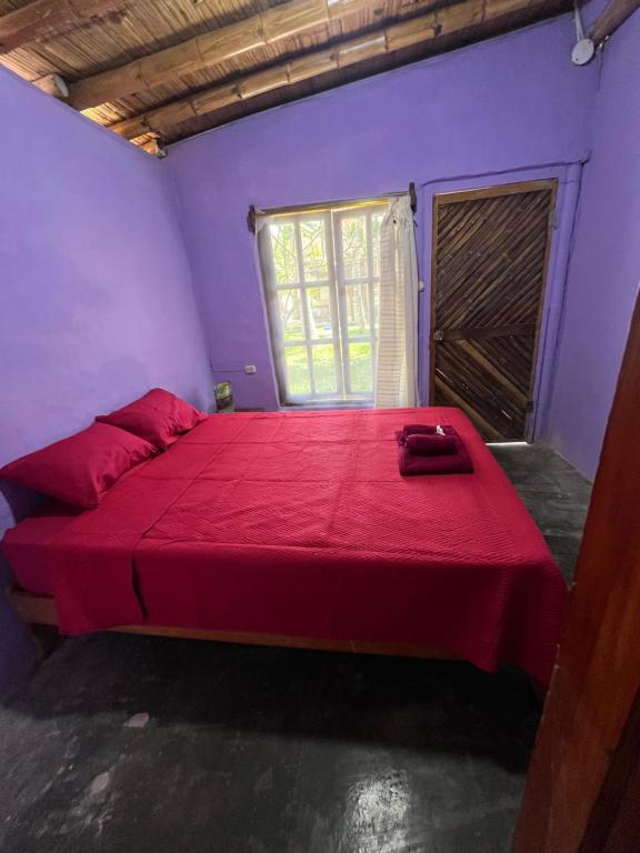 a bedroom with a large bed with a red blanket at Taroland in Máncora